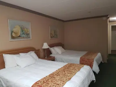 a hotel room with two beds and a lamp at Owen Sound Inn in Owen Sound