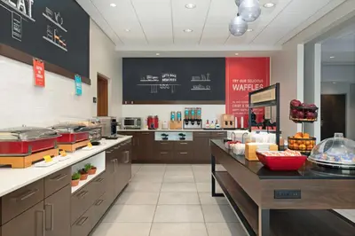 a large kitchen with a counter in a restaurant at Hampton Inn by Hilton Port Hope Cobourg in Port Hope