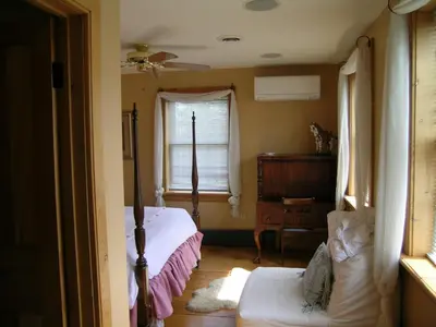 a bedroom with a bed and a dresser and a window at Emilyville Inn in Campbellford