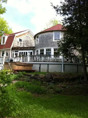 a large house with a fence in the yard at Windswept on the Trent in Campbellford
