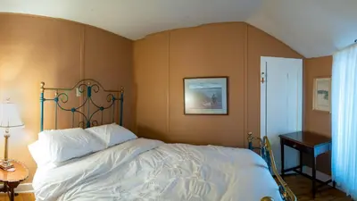a bedroom with a bed with a metal headboard at Windswept on the Trent in Campbellford