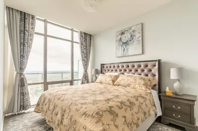 a bedroom with a bed and a large window at Urban Skyline in Toronto