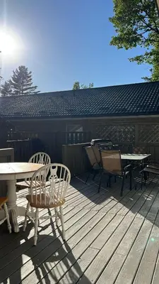 a wooden deck with a table and chairs on it at Wasaga Beach Cottage 2 in Wasaga Beach