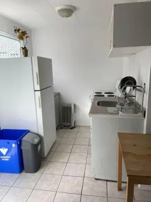 a kitchen with a refrigerator and a tile floor at Wasaga Beach Cottage 2 in Wasaga Beach