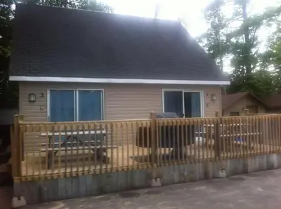 a house with a wooden fence in front of it at Wasaga Beach Loft 4 in Wasaga Beach