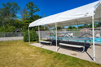 a white tent with a table and chairs next to a pool at Beach Club by Beach1 Motel in Wasaga Beach
