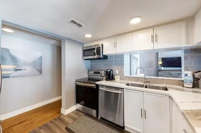 a kitchen with white cabinets and a sink at Wintergreen 127 in Blue Mountains