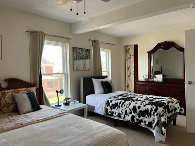 a bedroom with two beds and a mirror at Cheerful residence in Niagara Falls