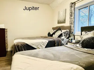 a room with two beds and a window at Cheerful residence in Niagara Falls