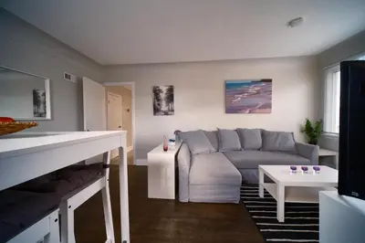 a living room with a couch and a table at Hamilton Chic Retreat - Comfy Beds - Garden - Pool in Hamilton