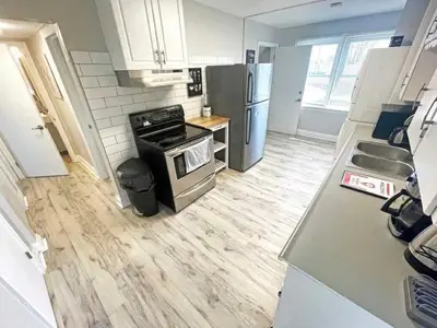 a kitchen with a stove and a refrigerator at Hamilton Chic Retreat - Comfy Beds - Garden - Pool in Hamilton