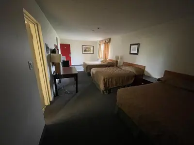 a hotel room with two beds and a desk at 6032 Persepolis Inn in Niagara Falls