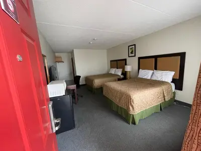 a hotel room with two beds and a red door at 6032 Persepolis Inn in Niagara Falls