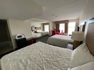 a hotel room with two beds and a television at 6032 Persepolis Inn in Niagara Falls
