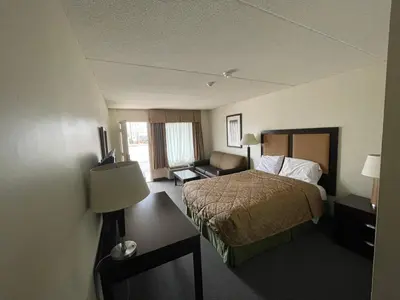 a hotel room with a bed and a couch at 6032 Persepolis Inn in Niagara Falls