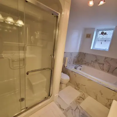 a bathroom with a shower and a tub and a toilet at Garden 2 Storey House in Niagara Falls