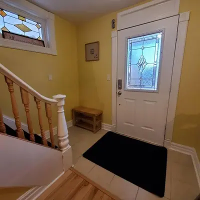 a hallway with a white door and a window at Garden 2 Storey House in Niagara Falls