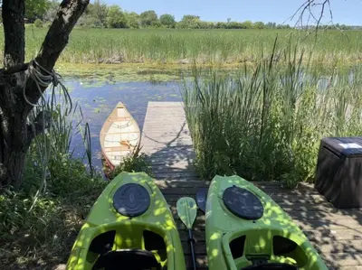 two kayaks on a dock next to a body of water at The Prince Edward County Church, A Unique Escape in Belleville