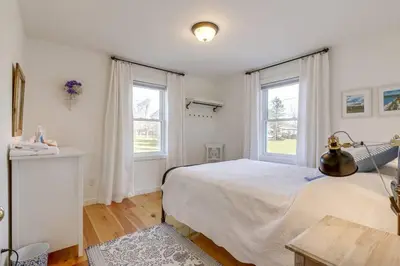 a bedroom with a large bed and two windows at The Prince Edward County Church, A Unique Escape in Belleville