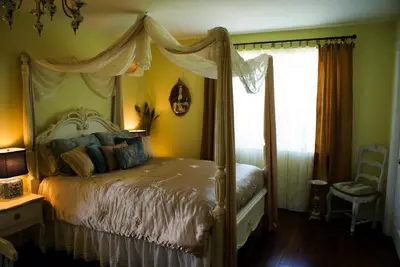 a bedroom with a canopy bed and a window at Sapience Retreat & Apothecary in Niagara on the Lake