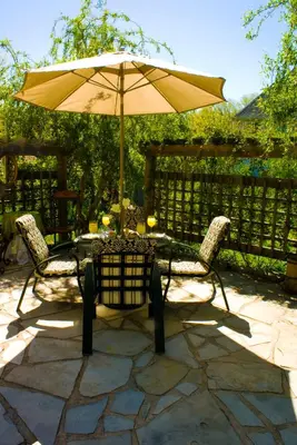 a table and chairs with an umbrella on a patio at Sapience Retreat & Apothecary in Niagara on the Lake