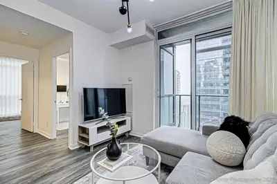 a living room with a couch and a tv at Prime Location - Stunning 2-bdrm Condo in Toronto
