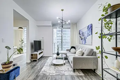a living room with a couch and a tv at Prime Location - Stunning 2-bdrm Condo in Toronto
