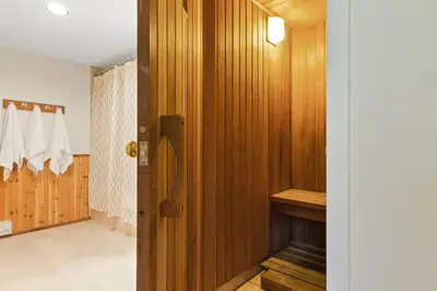 a bathroom with wood paneling and a wooden door at Lovely 3 Bedroom Wintergreen Retreat w Sauna in Blue Mountains