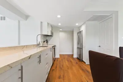 a kitchen with white cabinets and a refrigerator at Lovely 3 Bedroom Wintergreen Retreat w Sauna in Blue Mountains