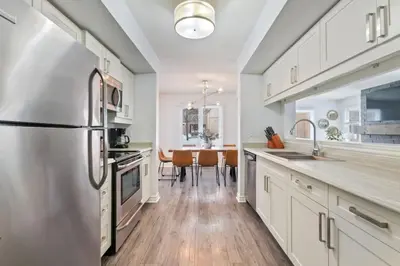 a kitchen with white cabinets and a refrigerator at Mountain Walk Chalet Across From Blue Mtn Village in Blue Mountains