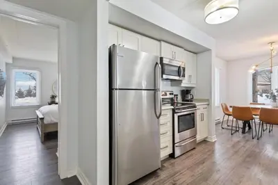 a kitchen with a stainless steel refrigerator and a dining room at Mountain Walk Chalet Across From Blue Mtn Village in Blue Mountains