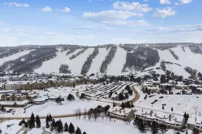 a ski resort covered in snow on a mountain at Contemporary Chalet Steps to Blue Mountain Village in Blue Mountains
