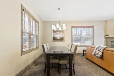 a dining room with a table and a couch at Blue Mtn Getaway in Historic Snowbridge Chalet in Collingwood