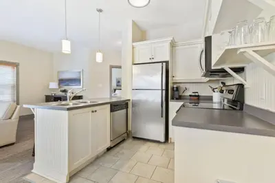 a kitchen with white cabinets and a stainless steel refrigerator at Blue Mtn Getaway in Historic Snowbridge Chalet in Collingwood