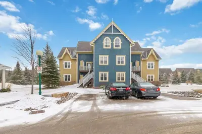 a large house with two cars parked in front of it at Blue Mtn Getaway in Historic Snowbridge Chalet in Collingwood