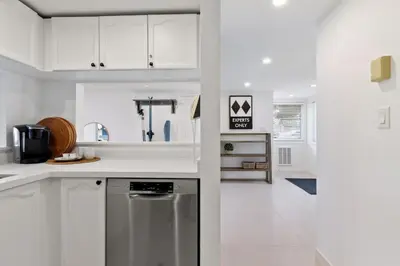 a kitchen with white cabinets and a stainless steel dishwasher at Luxury Blue Mtn Getaway w Indoor Sauna in Blue Mountains
