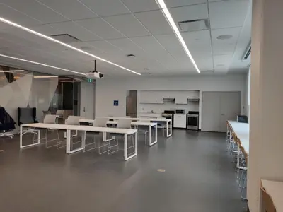 an empty office with white tables and chairs at Toronto Metropolitan University-Daphne Cockwell Complex Residence in Toronto