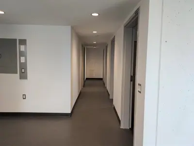 a hallway of an office building with white walls at Toronto Metropolitan University-Daphne Cockwell Complex Residence in Toronto