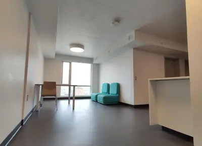 an empty room with a table and blue chairs at Toronto Metropolitan University-Daphne Cockwell Complex Residence in Toronto