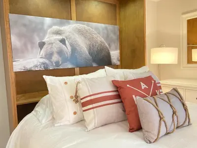 a picture of a bear above a bed with pillows at Modern Mountainside Ski In/Ski Out Studio at Blue in Blue Mountains