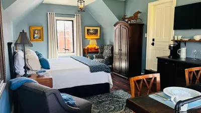 a bedroom with a bed and a chair and a table at Stone's Throw Stratford in Stratford