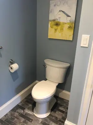 a bathroom with a toilet and a painting on the wall at Stone's Throw Stratford in Stratford