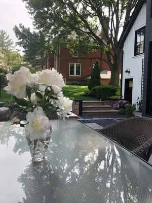 a vase of white flowers sitting on top of a table at Stone's Throw Stratford in Stratford