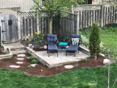 two chairs and a table in a yard at Stone's Throw Stratford in Stratford
