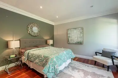 a bedroom with a bed and a mirror and a chair at Family Lakeside Oasis in Innisfil