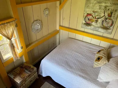 a small bedroom with a bed and a bike on the wall at Dreamers Writing Farm, 3 Wooded Acres, Hepworth in Sauble Beach