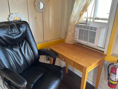 a black leather chair next to a desk and a window at Dreamers Writing Farm, 3 Wooded Acres, Hepworth in Sauble Beach