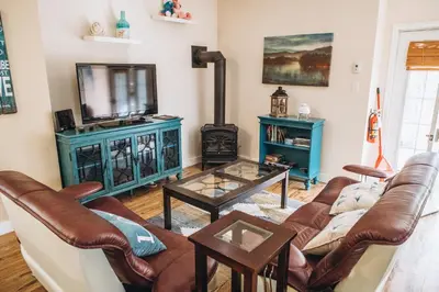 a living room with a couch and a stove at Dreamers Writing Farm, 3 Wooded Acres, Hepworth in Sauble Beach