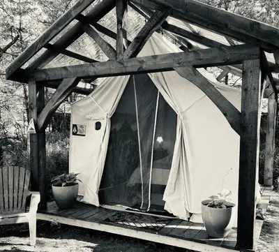 a white tent with two potted plants and a chair at Dreamers Writing Farm, 3 Wooded Acres, Hepworth in Sauble Beach