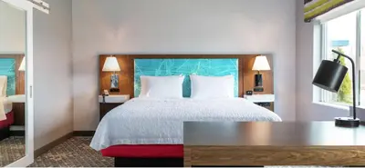a bedroom with a bed and a desk and a television at Hampton Inn Midland, On in Midland